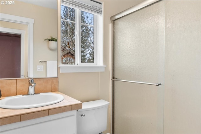 bathroom featuring tasteful backsplash, vanity, an enclosed shower, and toilet