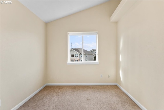 carpeted spare room with vaulted ceiling