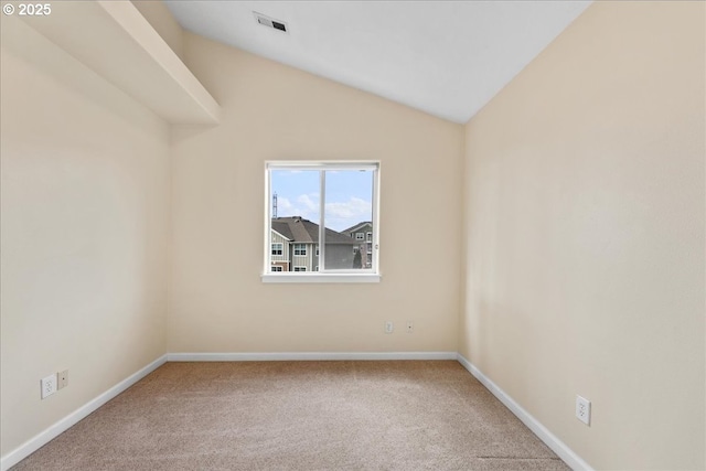 empty room featuring vaulted ceiling and carpet