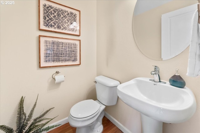 bathroom with hardwood / wood-style flooring, sink, and toilet