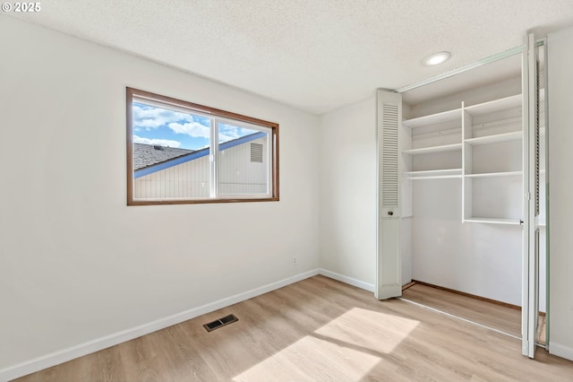 590 Granite Pl, Springfield, OR 97477 - unfurnished bedroom featuring light wood finished floors, a textured ceiling, and a closet
