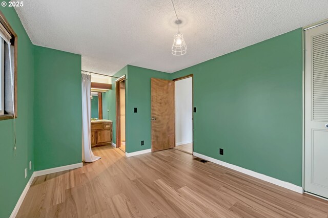 590 Granite Pl, Springfield, OR 97477 - unfurnished bedroom with a textured ceiling, light wood-type flooring, ensuite bathroom, and a closet