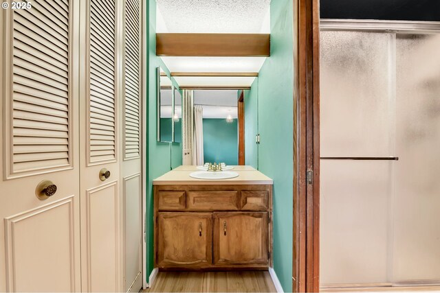 590 Granite Pl, Springfield, OR 97477 - bathroom featuring a closet, vanity, a shower stall, and wood finished floors