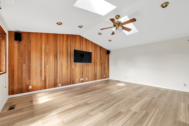 590 Granite Pl, Springfield, OR 97477 - unfurnished living room featuring a skylight, wood walls, lofted ceiling, light wood-style flooring, and ceiling fan