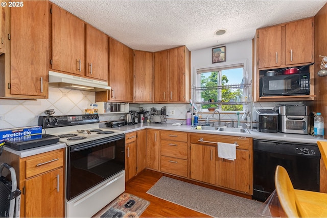 2710 SE 138th Ave Unit 48, Portland, OR 97236 - kitchen with black appliances, a sink, under cabinet range hood, light countertops, and a textured ceiling