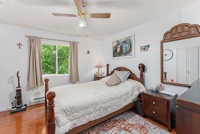 2710 SE 138th Ave Unit 48, Portland, OR 97236 - bedroom featuring wood finished floors, a baseboard radiator, and ceiling fan