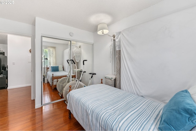 2710 SE 138th Ave Unit 48, Portland, OR 97236 - bedroom with wood finished floors, a closet, baseboards, and a textured ceiling