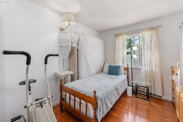 2710 SE 138th Ave Unit 48, Portland, OR 97236 - bedroom with wood finished floors, a textured ceiling, and baseboards