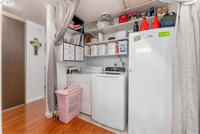 2710 SE 138th Ave Unit 48, Portland, OR 97236 - laundry area with washer and clothes dryer, light wood finished floors, baseboards, and a textured ceiling