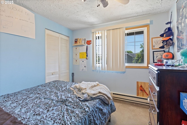 410 W Jefferson St, Carlton, OR 97111 - bedroom featuring a baseboard heating unit, carpet, a closet, a textured ceiling, and a ceiling fan