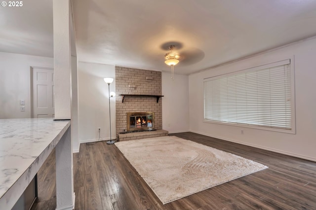 600 NE 144th Ave, Vancouver, WA 98684 - unfurnished living room with dark wood-type flooring, a ceiling fan, a brick fireplace, and baseboards
