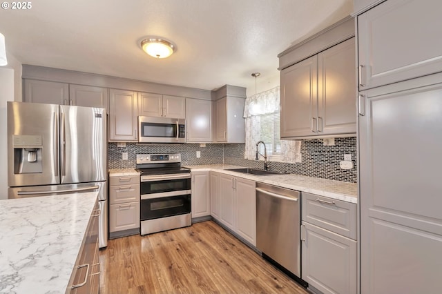 600 NE 144th Ave, Vancouver, WA 98684 - kitchen featuring appliances with stainless steel finishes, a sink, gray cabinetry, and tasteful backsplash