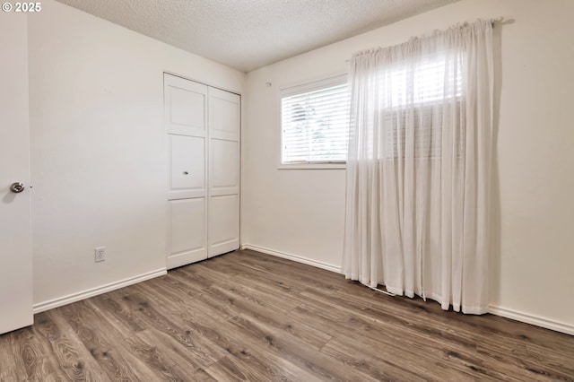 600 NE 144th Ave, Vancouver, WA 98684 - unfurnished bedroom with wood finished floors, a textured ceiling, a closet, and baseboards