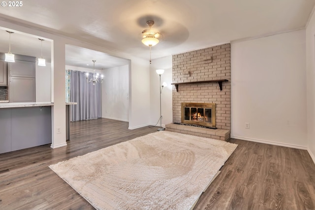 600 NE 144th Ave, Vancouver, WA 98684 - unfurnished living room featuring dark wood-style floors, a chandelier, a brick fireplace, and baseboards