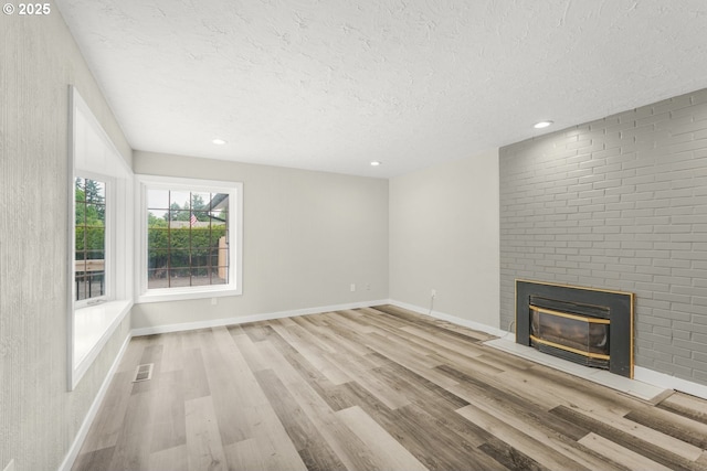 14108 NE 49th St, Vancouver, WA 98682 - unfurnished living room with a textured ceiling, a fireplace, wood finished floors, baseboards, and recessed lighting