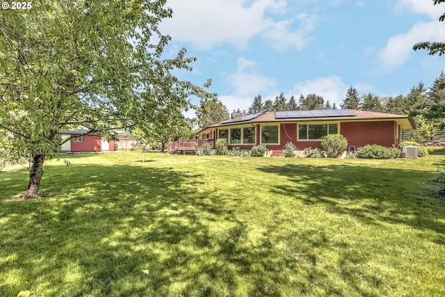 view of grassy yard featuring central air condition unit and a deck