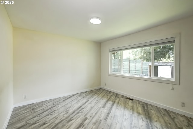 spare room with wood finished floors and baseboards