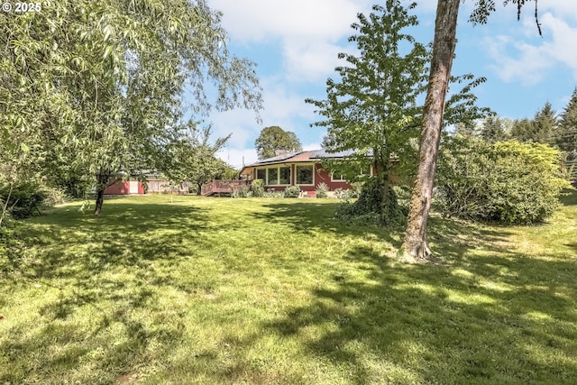 view of grassy yard with a wooden deck