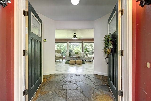entrance foyer featuring a ceiling fan, baseboards, and wood finished floors