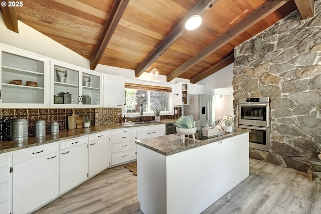 kitchen featuring a sink, appliances with stainless steel finishes, light wood finished floors, wooden ceiling, and a center island