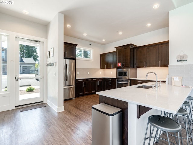 1856 NW Sierra Way, Camas, WA 98607 - kitchen with appliances with stainless steel finishes, a peninsula, dark brown cabinetry, a breakfast bar area, and recessed lighting