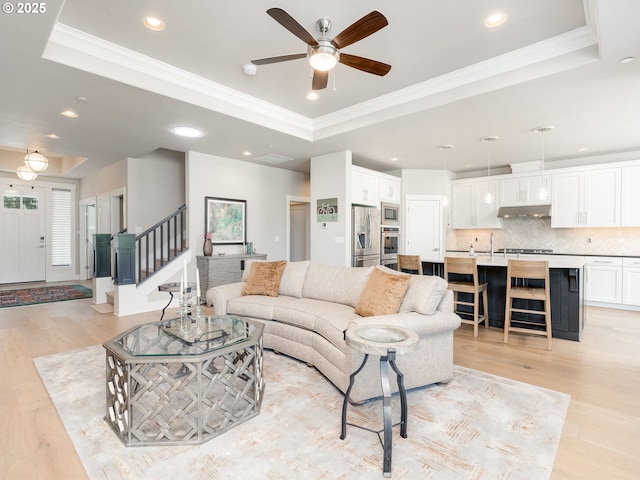 1856 NW Sierra Way, Camas, WA 98607 - living area featuring a raised ceiling, light wood finished floors, ceiling fan, recessed lighting, and ornamental molding