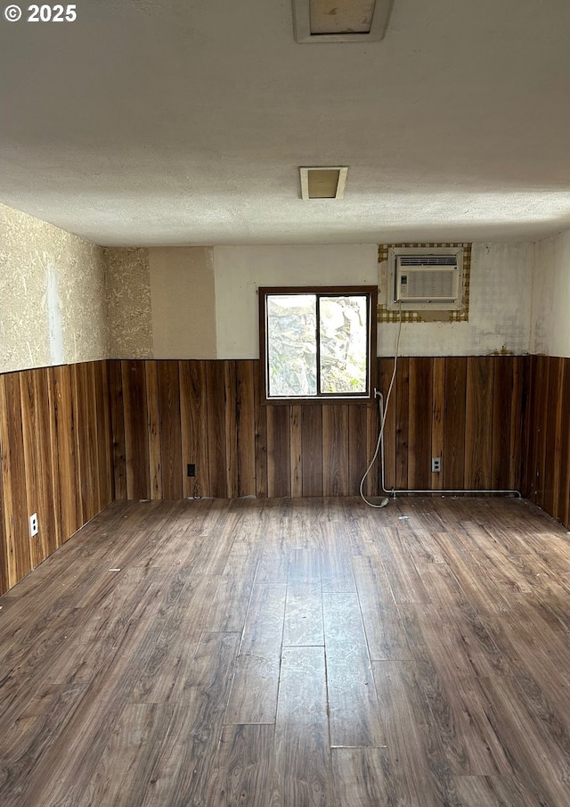 unfurnished room featuring dark wood-type flooring and a wall mounted AC