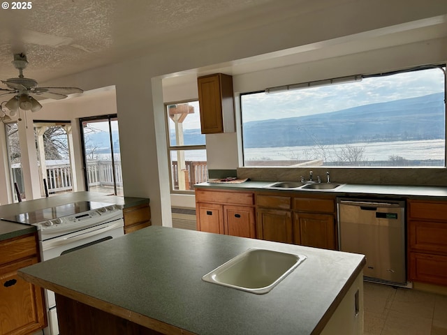 kitchen featuring sink, a textured ceiling, white electric stove, dishwasher, and a kitchen island