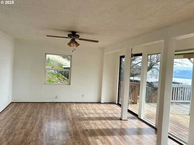 spare room featuring ceiling fan, hardwood / wood-style flooring, and a textured ceiling