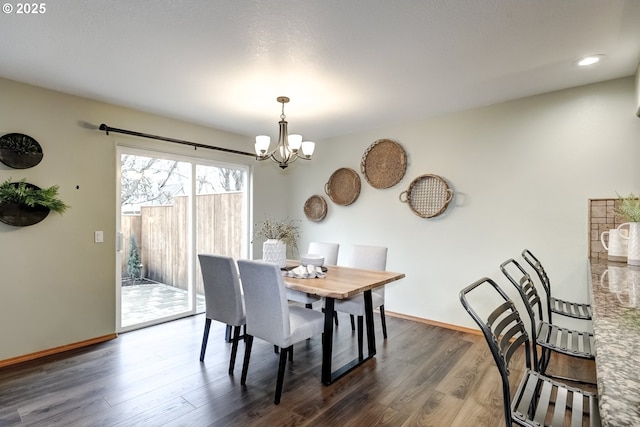 dining area with dark wood-type flooring and a chandelier