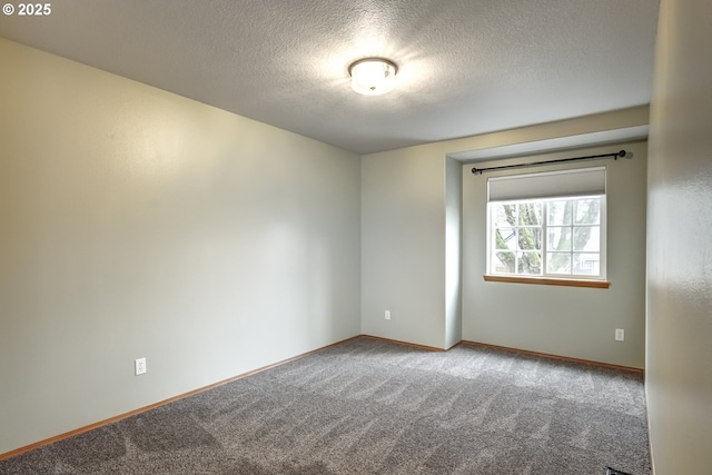 carpeted spare room with a textured ceiling