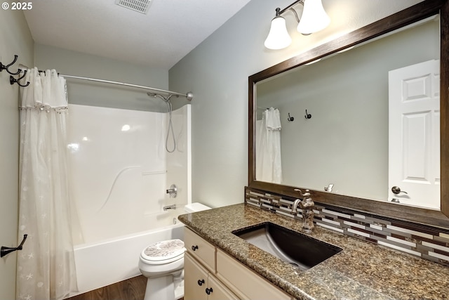 full bathroom featuring shower / bathtub combination with curtain, vanity, hardwood / wood-style floors, and toilet