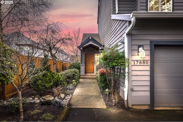 exterior entry at dusk featuring a garage