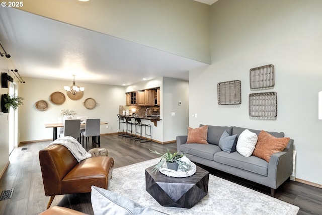 living room with dark hardwood / wood-style flooring, a notable chandelier, and sink