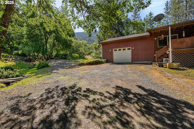 905 Summit Loop, Grants Pass, OR 97527 - view of side of home with an attached garage, gravel driveway, and stairway