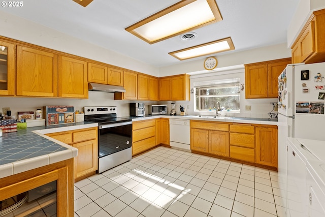 905 Summit Loop, Grants Pass, OR 97527 - kitchen featuring appliances with stainless steel finishes, under cabinet range hood, tile countertops, and a sink