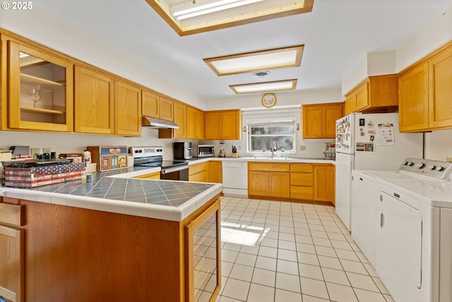 905 Summit Loop, Grants Pass, OR 97527 - kitchen with stainless steel electric range, independent washer and dryer, white dishwasher, under cabinet range hood, and a peninsula