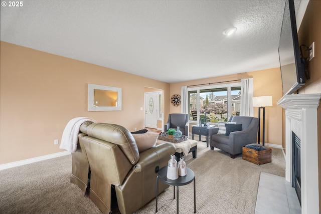 living room with a fireplace with flush hearth, carpet floors, baseboards, and a textured ceiling