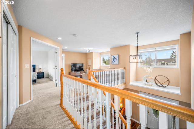 hallway with recessed lighting, baseboards, carpet flooring, and an upstairs landing