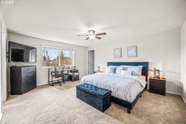 carpeted bedroom featuring a textured ceiling, a ceiling fan, and baseboards