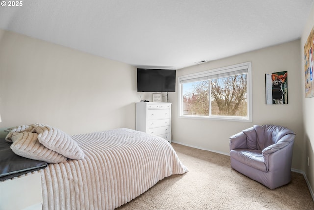 carpeted bedroom featuring baseboards and visible vents