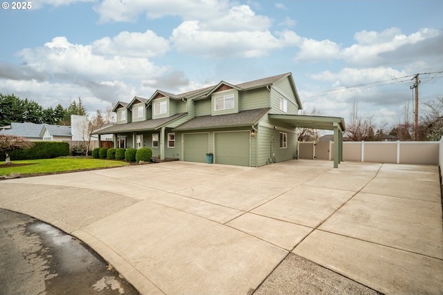 view of front of property with a garage, concrete driveway, roof with shingles, fence, and a front yard