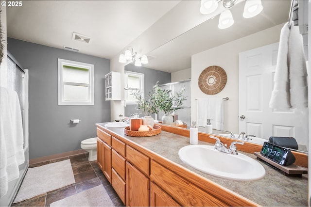 bathroom featuring double vanity, a stall shower, visible vents, and a sink