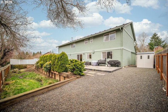 rear view of property featuring an outbuilding, a patio, a storage shed, and a fenced backyard