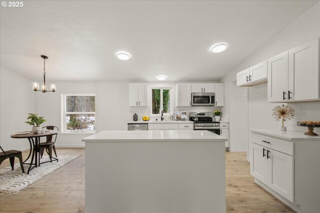 662 Cannavina Rd, Carson, WA 98610 - kitchen featuring appliances with stainless steel finishes, light wood-style flooring, white cabinetry, and healthy amount of natural light