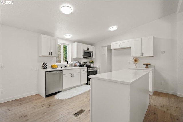 662 Cannavina Rd, Carson, WA 98610 - kitchen with stainless steel appliances, light wood-style flooring, white cabinets, light countertops, and vaulted ceiling