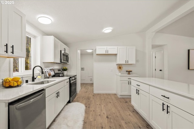 662 Cannavina Rd, Carson, WA 98610 - kitchen with appliances with stainless steel finishes, vaulted ceiling, light wood-style floors, white cabinetry, and light countertops