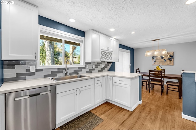 kitchen featuring sink, hanging light fixtures, white cabinets, and dishwasher