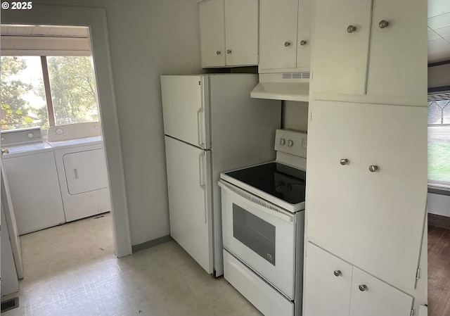kitchen with white appliances, under cabinet range hood, washer and dryer, and plenty of natural light