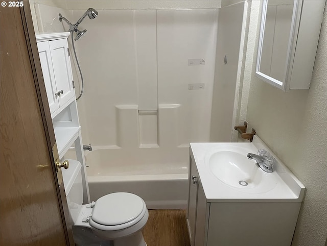 full bathroom with wood finished floors, vanity, toilet, bathtub / shower combination, and a textured wall